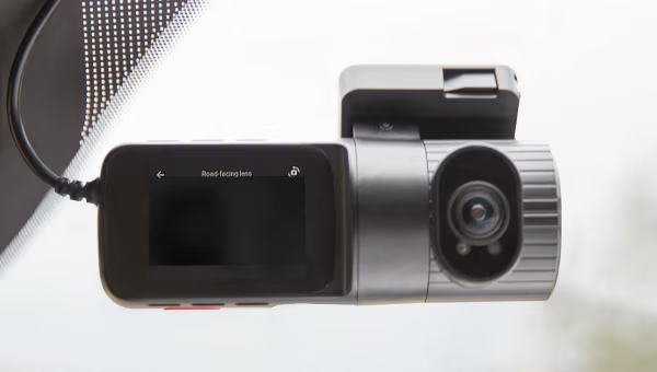 Mounted car dashcam with a screen and lens, capturing road footage for safety and security.